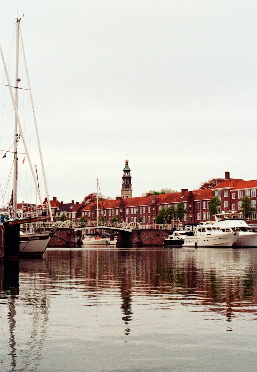 Boats are docked in a scenic, european harbor.